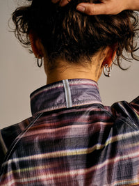 Back view of Jog Jacket in a colorful plaid pattern, featuring a reflective detail on the collar.