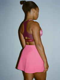 Model in profile wearing LightSpeed Minimal 3" Skort in Pink, featuring a built-in shorts liner.