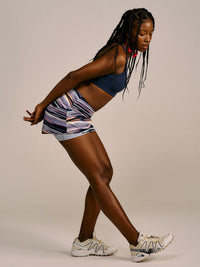Model stretching in LightSpeed Minimal 3" Skort in Navy, featuring built-in shorts liner and stylish print.