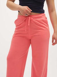 Model wearing Malibu Sweatpant in Coral, featuring a relaxed wide leg design with an elastic waistband.