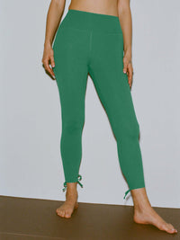 Model wearing Puddle Legging in Green, featuring adjustable ties at the back of the leg.