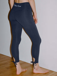 Back view of Puddle Legging in Navy, featuring adjustable ties at the ankle for a customizable fit.