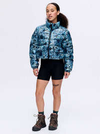 Model wearing Rainy Floral Puff in blue floral print, styled for outdoor adventures with shorts and hiking boots.