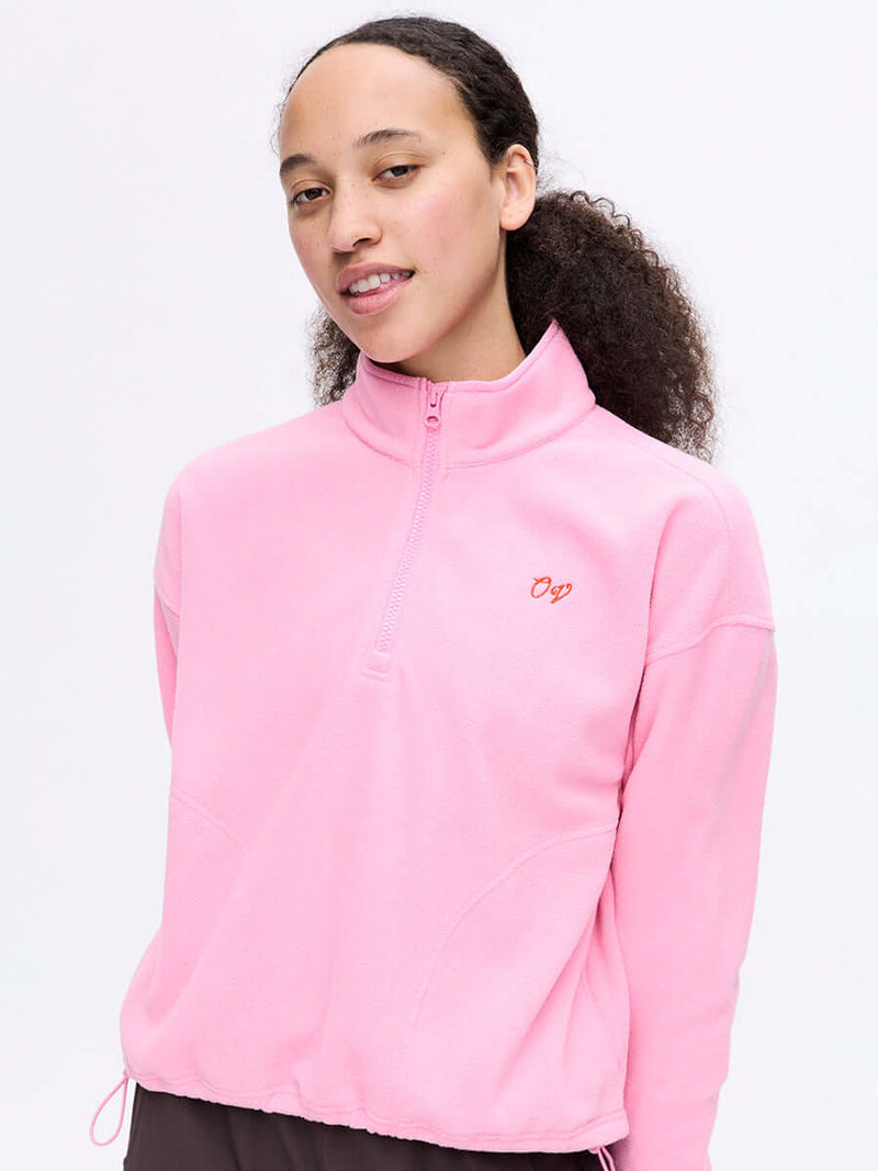 Model wearing RecFleece 1/4 Zip in Pink, featuring a front ¼ zip and adjustable hem toggle.