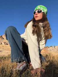 Model crouching outdoors in RecFleece 1/4 Zip, showing relaxed fit and paired with denim pants.
