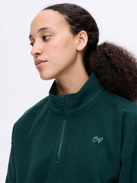 Model wearing RecFleece 1/4 Zip in Dark Green with a front zipper and a soft fleece texture.