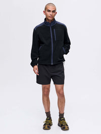 Model standing in the RecFleece Relaxed Full Zip jacket in Black, featuring contrast shoulder panels and pockets.