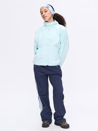 Model standing in light blue RecFleece Snap Jacket with snap closure and relaxed fit, paired with navy pants.