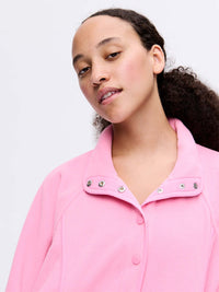 Model wearing RecFleece Snap Jacket in Pink with snap front and relaxed fit.