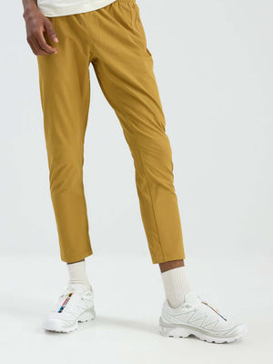 Model in relaxed fit RecTrek Pant in Gold, featuring a pull-on design and stretchy material for easy movement.