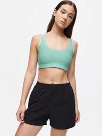 Model wearing RecTrek 4" Short in Black, styled with a matching green cropped tank top.