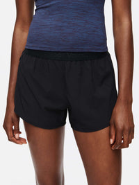 Model wearing Relay 3" Short in Black with elastic waistband, ideal for medium to high-sweat activities.