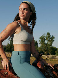 Ride Pant worn by a model sitting on a horse outdoors, with its stylish design and comfort.
