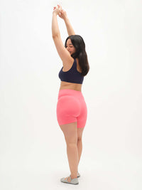 Model stretching in Echo 5.5" Short in Cotton Candy, featuring a tall waistband and supportive stretch.