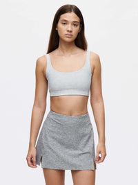 Model wearing Warmup 2.5" Skort in Grey, featuring a stylish design with side slits for added movement.