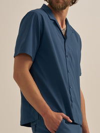 Model posing in SolarCool Camp Collar, wearing a blue lightweight shirt with a relaxed fit, ideal for outdoor activities.