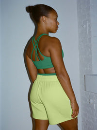 Model in profile wearing Sport Short in Neon Green with an adjustable waistband, styled for everyday wear.
