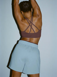 Back view of model wearing Star Bra in Maroon with intersecting straps for added support.