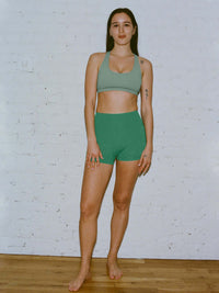 Model wearing Star Bra in Sage with a U-neck style and wide shoulder straps, paired with matching shorts.