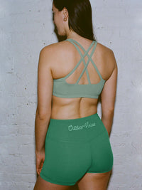 Back view of Star Bra in Sage Green, featuring intersecting straps for support and paired with matching shorts.