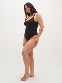 Model posing in Strappy Bodysuit in Black with adjustable spaghetti straps, ideal for everyday wear.