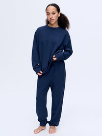 Model wearing Stratus Sweatpant in Navy, relaxed silhouette with a comfortable fit for lounging.