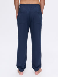 Model from the back wearing Stratus Sweatpant in Navy, featuring a relaxed fit and back pockets.