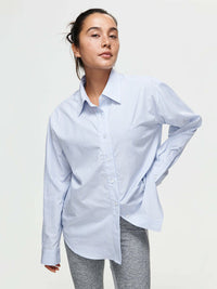 Model wearing Striped Sun Shirt in light blue, oversized fit with subtle stripes.