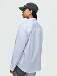 Model from the back wearing Striped Sun Shirt in Light Blue, featuring subtle stripes and an oversized fit.