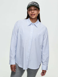 Model wearing Striped Sun Shirt in light blue with subtle stripes and oversized fit, styled for casual wear.