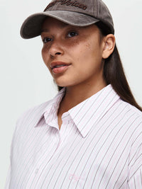 Model wearing a Striped Sun Shirt with subtle stripes and a cap, with the lightweight cotton poplin fabric.