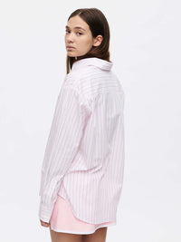 Model wears a Striped Sun Shirt featuring subtle stripes and an oversized fit, for sunny days.