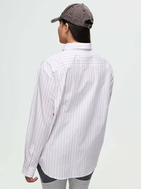 Back view of a person wearing a Striped Sun Shirt with subtle stripes and a cap, with an oversized fit.