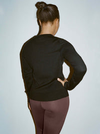 Back view of model in Sugar Cardigan in Black, featuring a soft knit and updated fit for easy wear.