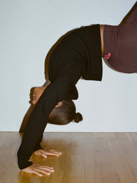 Model in a handstand wearing Sugar Cardigan in Black, with the relaxed fit and comfortable design.
