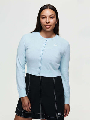 Model wearing Sugar Cardigan in Light Blue, lightweight knit cotton cashmere with hand-embroidered signature.