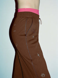 Side view of Sunny Sweatpant in Brown with a technical nylon waistband and fun embroidered details.