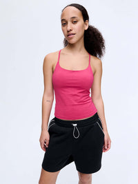 Model wearing TechSweat Move Free Tank in Pink with adjustable straps, styled for activewear.