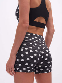 Back view of model wearing TechSweat 3.5" Short in Black with white polka dots, featuring a high-rise waistband.