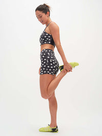 Model stretching in TechSweat 3.5" Short with polka dots, high-rise comfort for active movement.