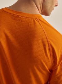 Back view of ThinkFast Mesh Shortsleeve in vibrant orange, with breathable fabric texture.