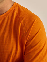 Close-up of ThinkFast Mesh Shortsleeve in Bright Orange, featuring breathable mesh fabric.