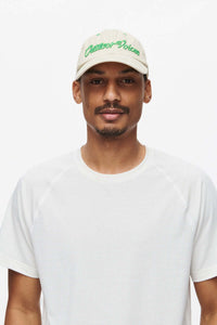Model wearing ThinkFast Mesh Shortsleeve in White paired with a beige cap, embodying activewear style.
