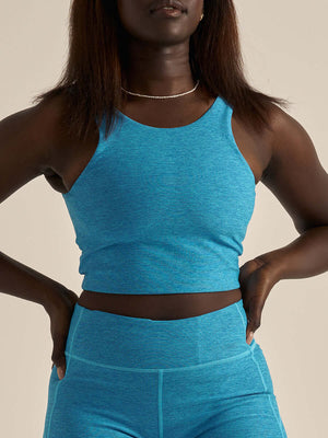 Model wearing Venus Crop Top in bright blue, with the sleek V-back design.