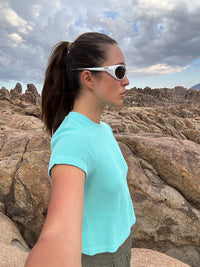 Side profile of model wearing Waffle Baby Tee in Aqua, with the waffle knit texture and relaxed fit.