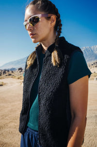 Model wearing Waffle Baby Tee in Green, paired with a cozy vest and sporty sunglasses for outdoor adventures.