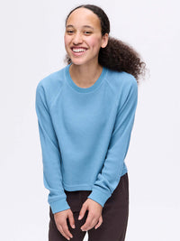 Smiling model wearing Waffle Longsleeve in light blue, showing the soft waffle knit fabric.