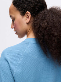 Model displaying the back view of Waffle Longsleeve in Light Blue, with the waffle knit texture.
