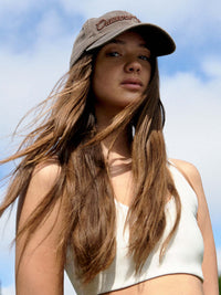 Model outdoors wearing Washed Hat in Gray with raised signature stitching and a relaxed fit.