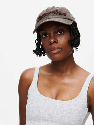 Model wearing Washed Hat in Brown, featuring raised Outdoor Voices signature.